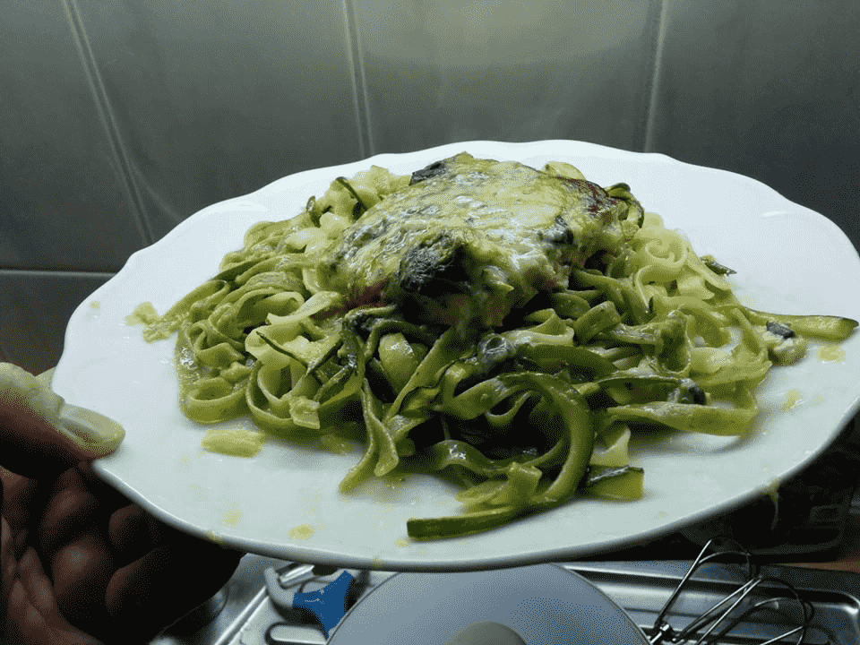 Teller Pasta mit grünen Zucchini Streifen und Lachs