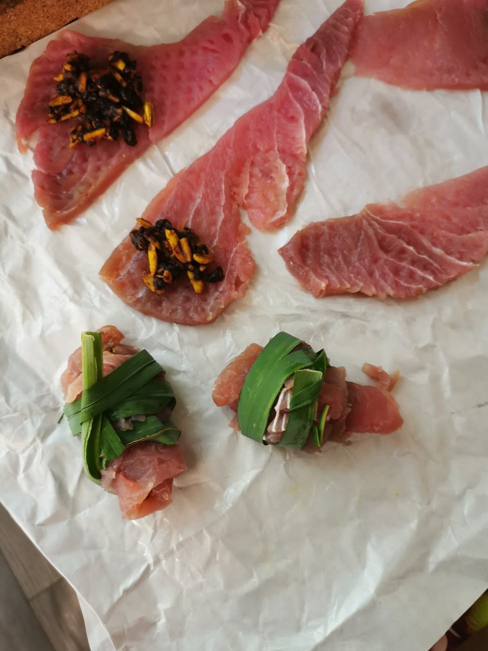 Tunfisch Scheiben, teilweise gefüllt mit Rosinen, Mandelstifte, Gewürzen und gebunden mit Palmblatt